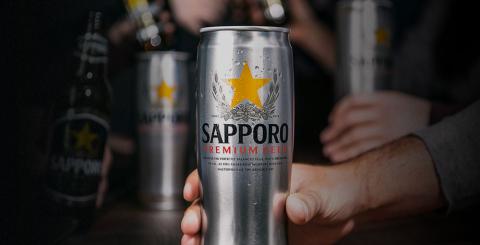 Man holding Sapporo premium beer