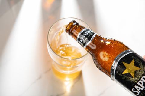 Sapporo Premium beer bottle pouring into glass