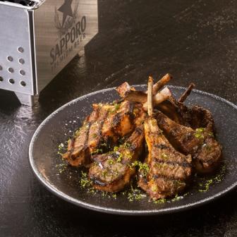 Sapporo beer served with robata lamb chops with red miso and lime zest